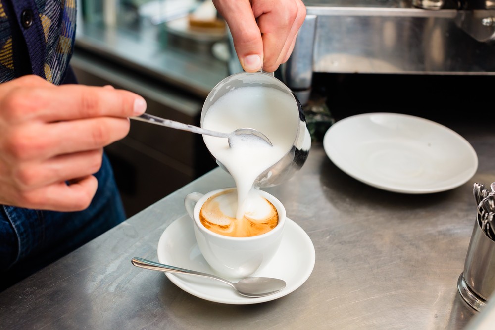 barista sirviendo un café en una taza